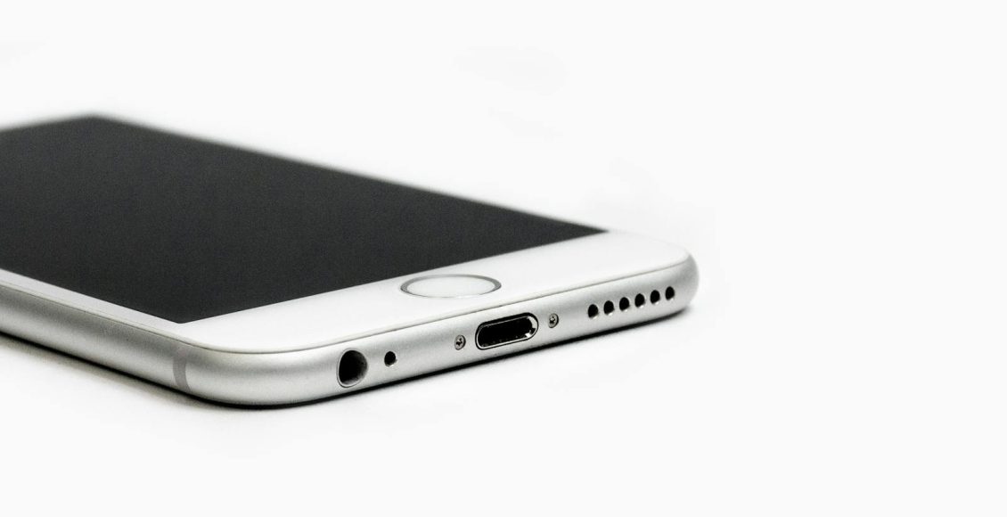Minimalist image of a sleek smartphone with focus on the bottom edge and ports.