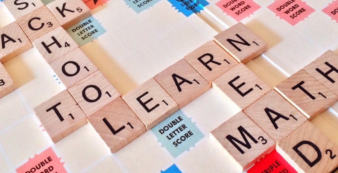 Close-up of Scrabble tiles forming words related to education and school.