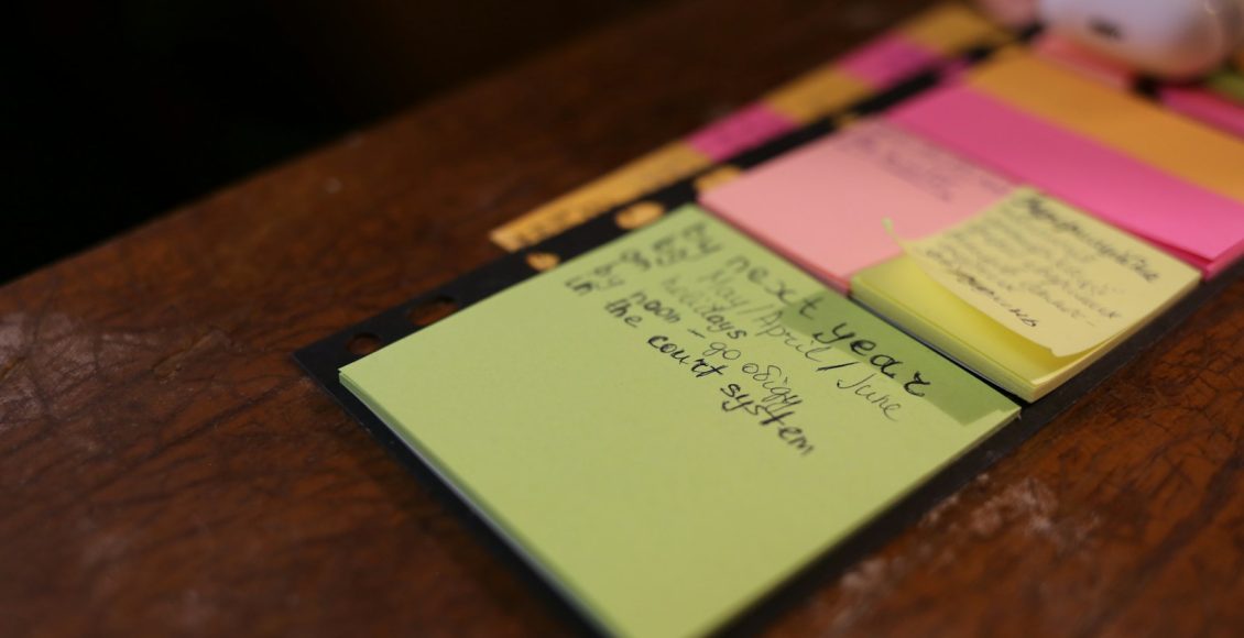 green sticky note on brown surface