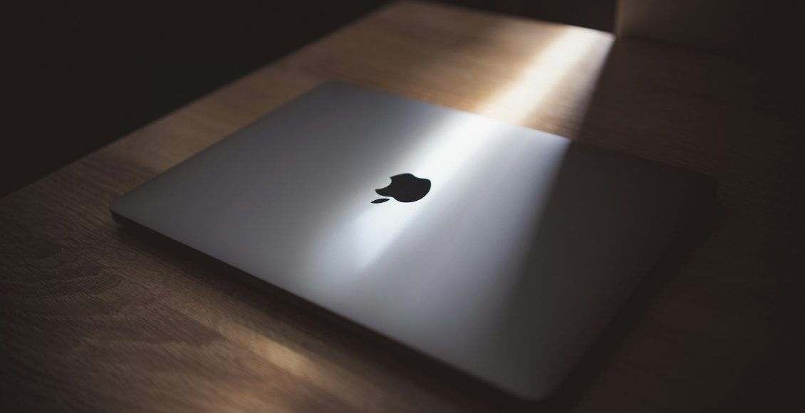 silver macbook on brown wooden table
