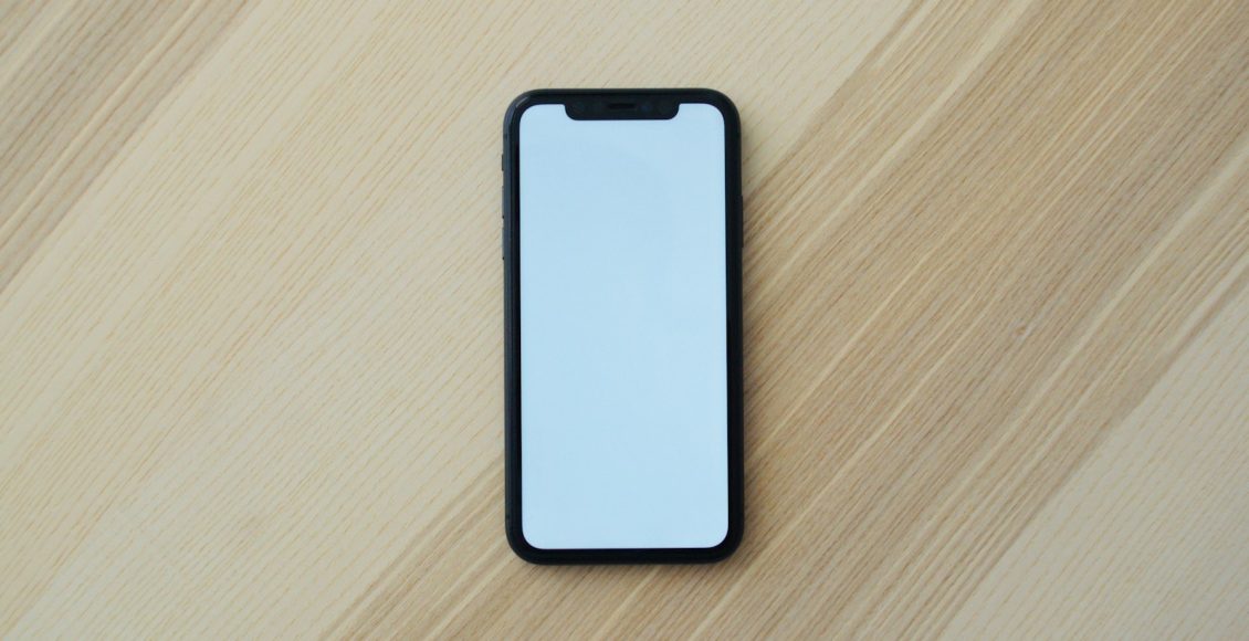white smartphone on brown wooden table