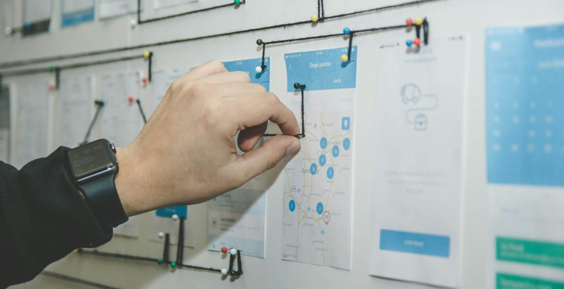 person working on blue and white paper on board