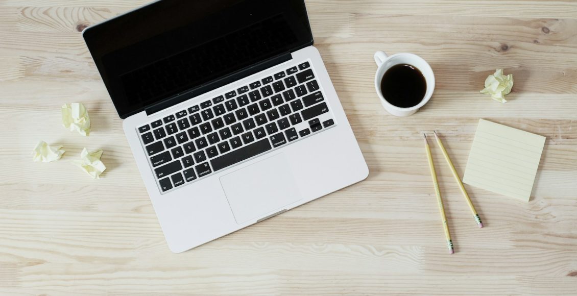 turned off MacBook Pro beside white ceramic mug filled with coffee