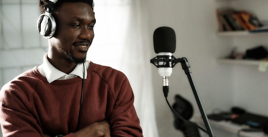 a man wearing headphones standing in front of a microphone
